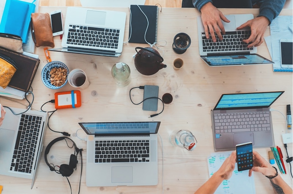 Equipo de trabajo colaborando con laptops en una oficina moderna.